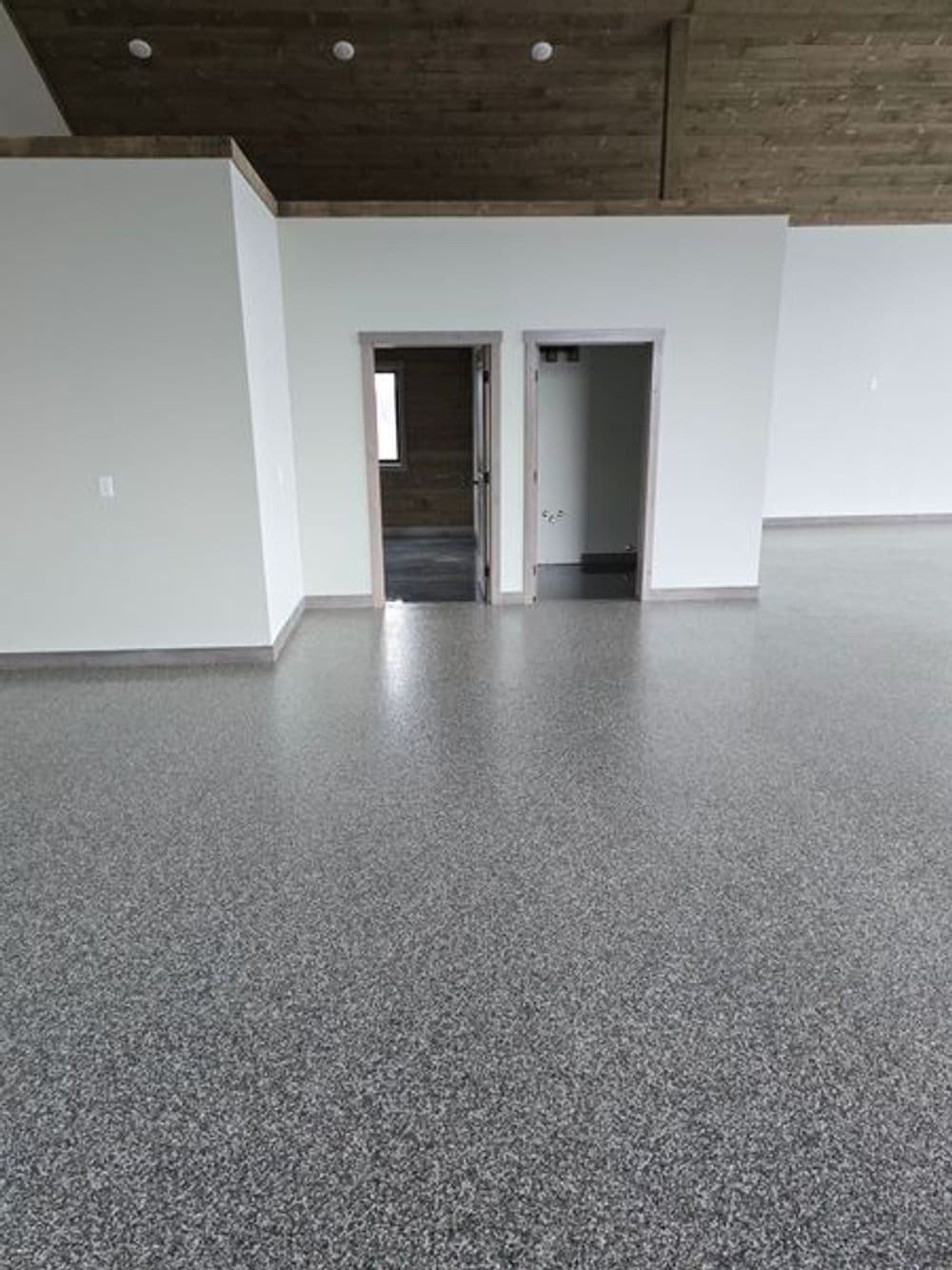 Spacious interior with polished concrete floor and two doorways in a modern room.