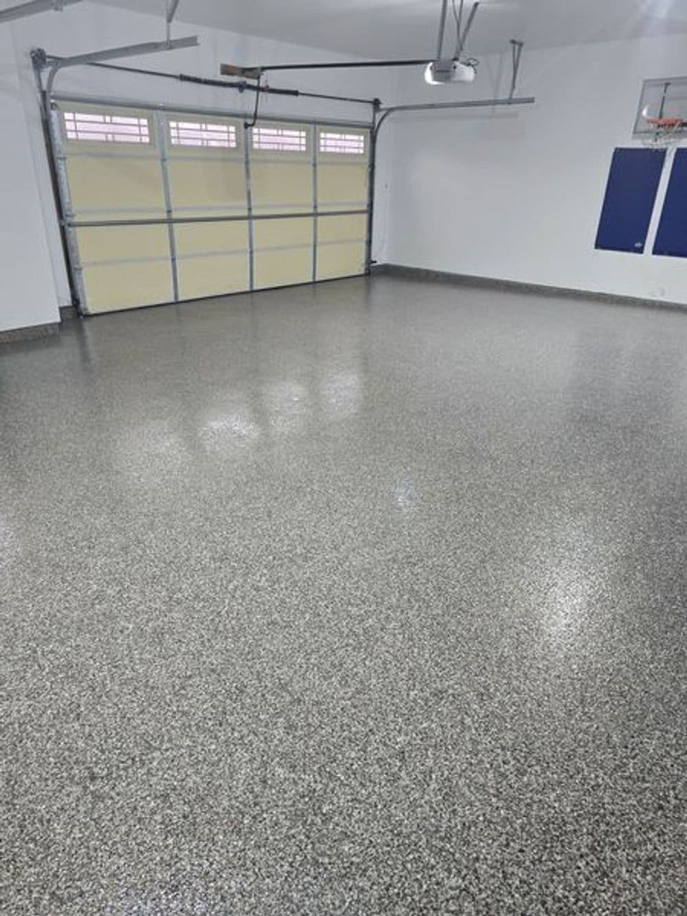 Clean, polished garage floor with epoxy finish and ample natural light from overhead windows.