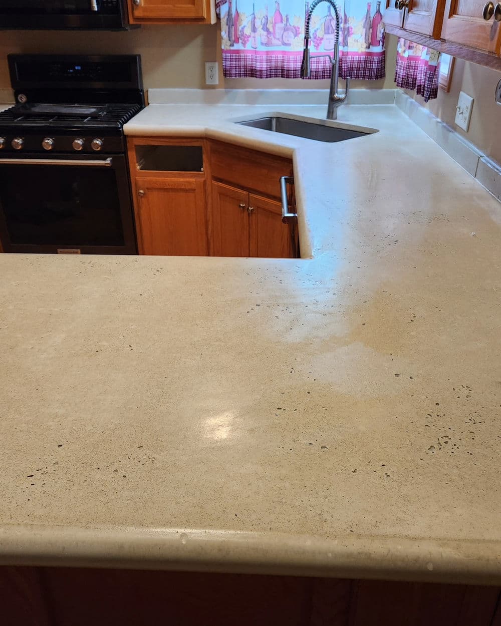 Modern kitchen with a smooth, light-colored countertop and stainless steel sink.